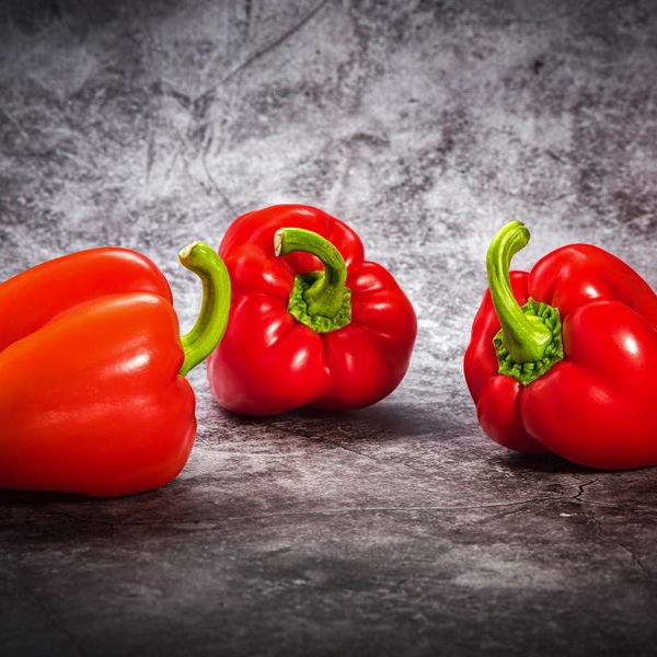 Három piros kaliforniai paprika kőfelületen